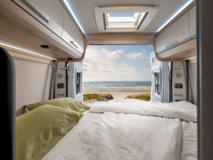 KNAUS BOXLIFE PLATINUM SELECTION 2027 – Heckbett mit Blick nach draußen Schlafbereich im KNAUS BOXLIFE PLATINUM SELECTION 2027 mit großem Heckbett, geöffneten Hecktüren und Blick auf das Meer